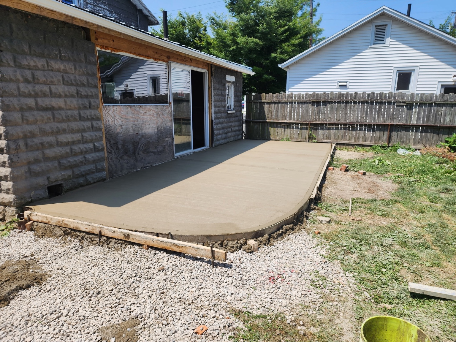 New concrete patio with a curved outside edge and forms still in place.