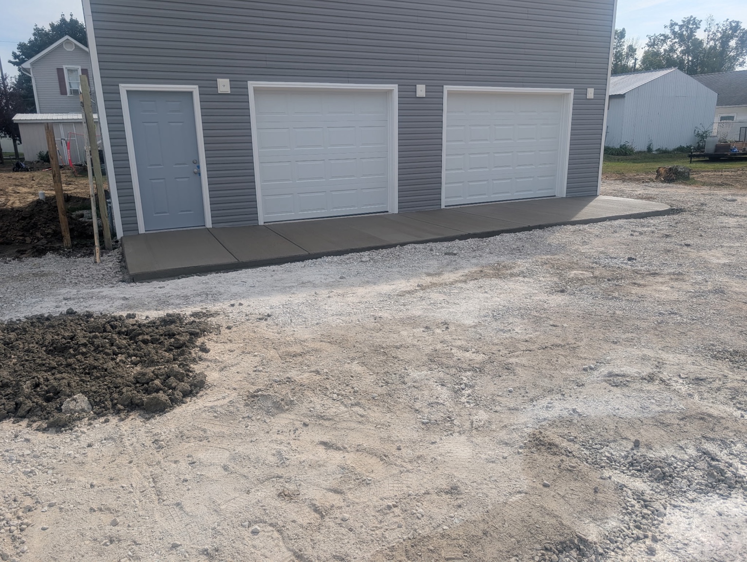 Concrete apron across two garage doors and a side entrance.