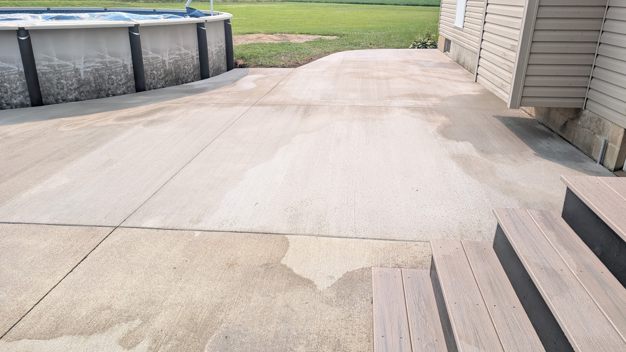 Concrete patio beside an above-ground pool, with visible control joints.