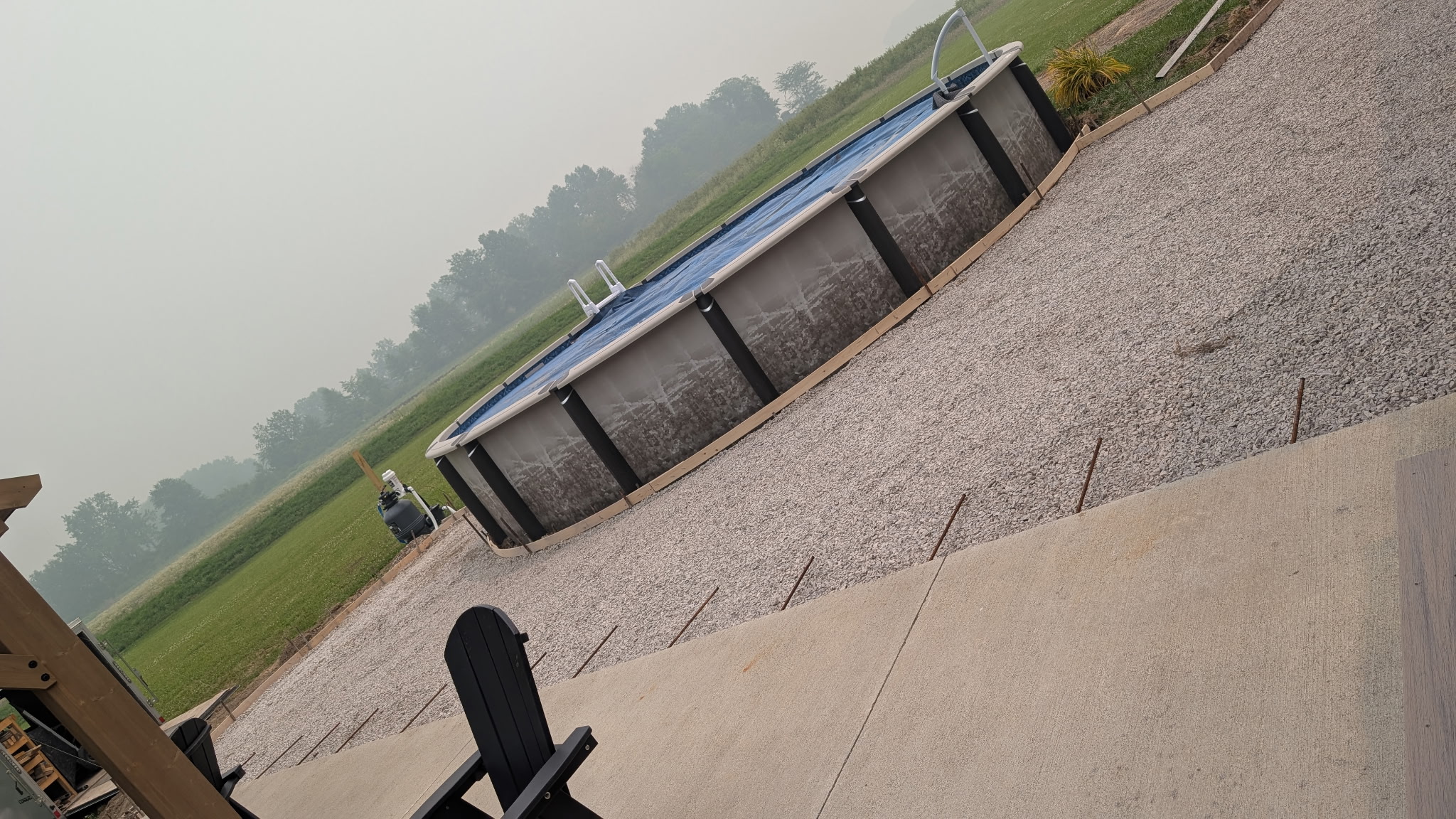 Poolside area with prepared aggregate and an adjacent concrete section.