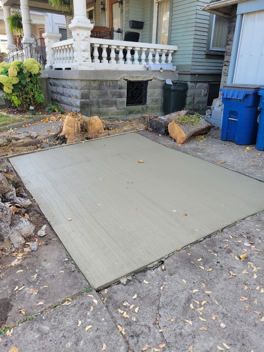 Replacement concrete panel adjacent to existing paving.