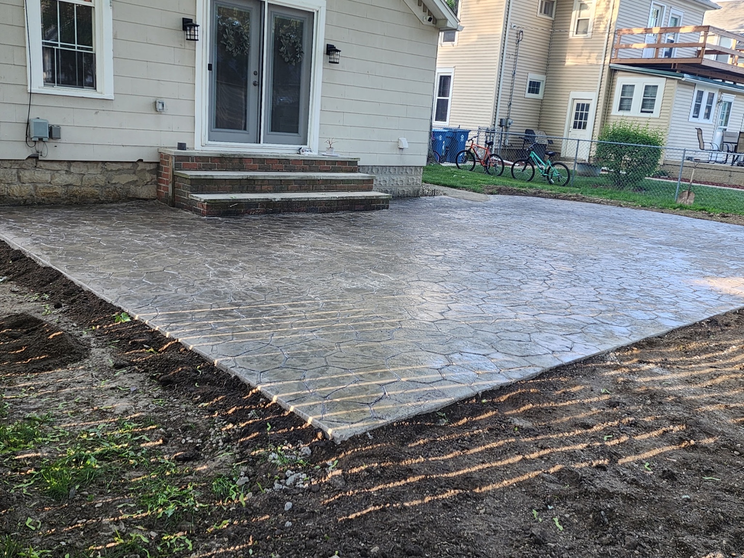 Decorative stamped concrete patio outside a residential entrance.